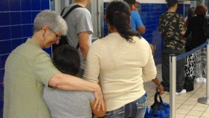 Sister Sharon Altendorf  hugs 8-year-old Joanna as the girl and her mother, Karen, await their bus in San Antonio. They are bound for Amarillo, Texas, where they will stay with a host family. (Molly Hennessy-Fiske / Los Angeles Times)