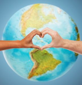 human hands showing heart shape over earth globe